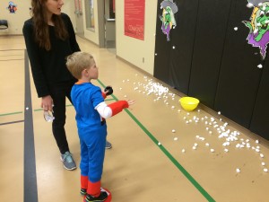 Captain America (Brecken) trying to get cotton balls stuck on the wall