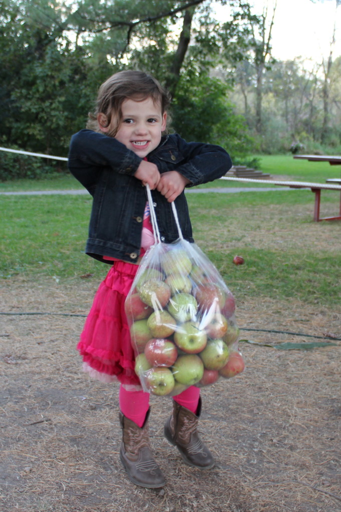 Madiana showing how strong he is by holding up the bag of apples