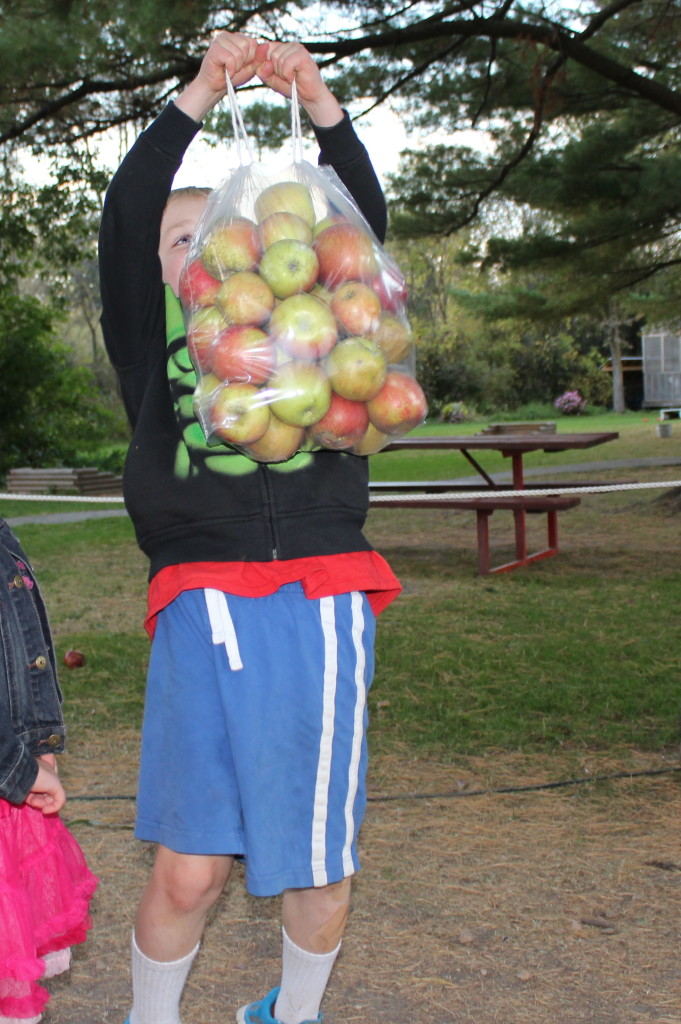 Brecken showing how strong he is by holding up the bag of apples